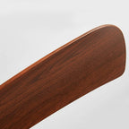 Close-up of a sleek, rounded walnut wood ceiling fan blade with a natural grain finish for a Scandinavian interior.