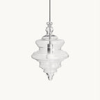 Sculptural clear glass pendant light with a rippled, theatre-inspired silhouette and a central filament bulb.