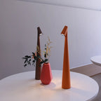 Slim, 33cm cordless LED table lamps in brown and orange on a white table next to a small pink vase.