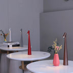 Slim, 33cm cordless LED table lamps in red, brown, grey, and white on modern circular tables with minimalist decor.