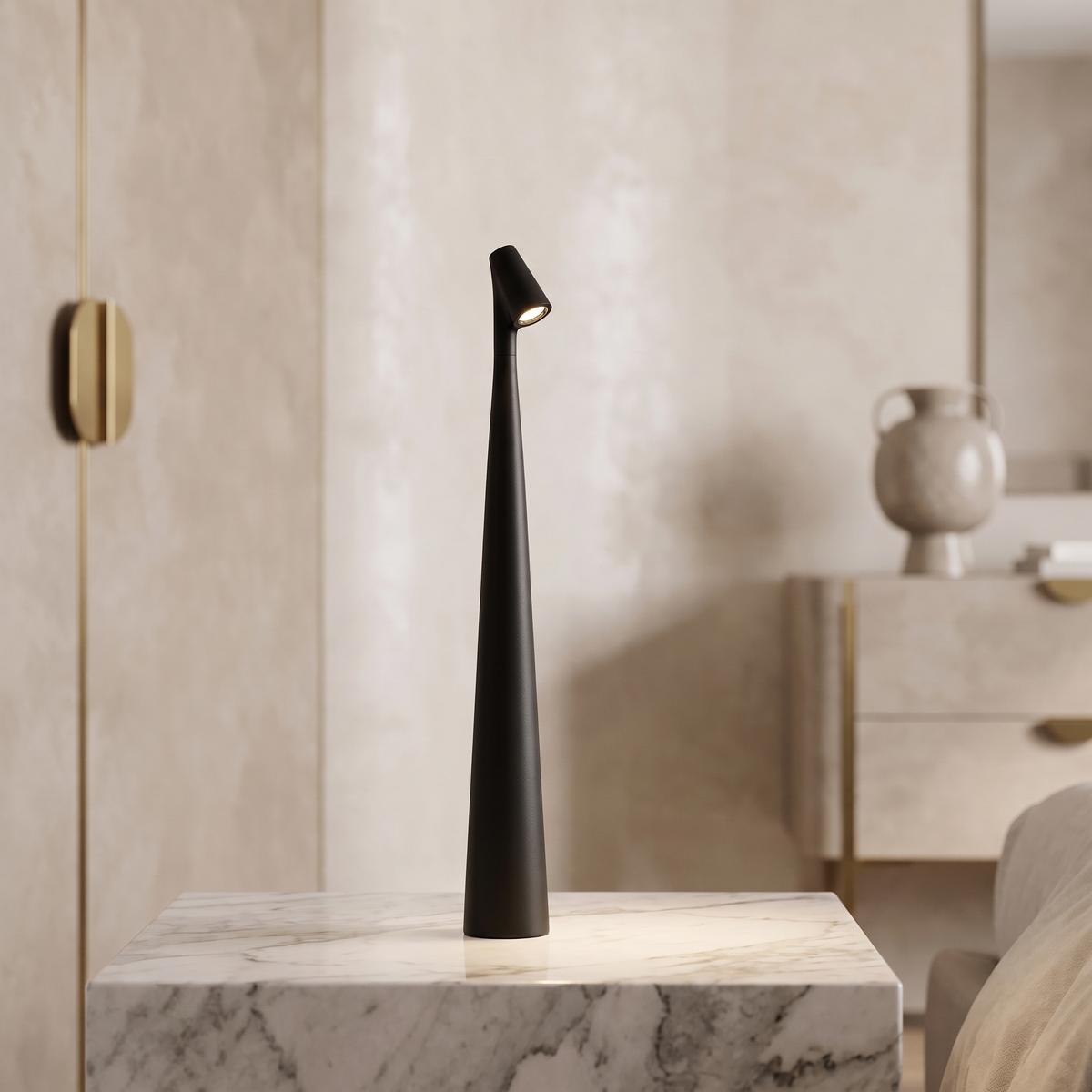 Slim black cordless LED table lamp with a minimalist 33cm tapered design, glowing on a white marble surface.