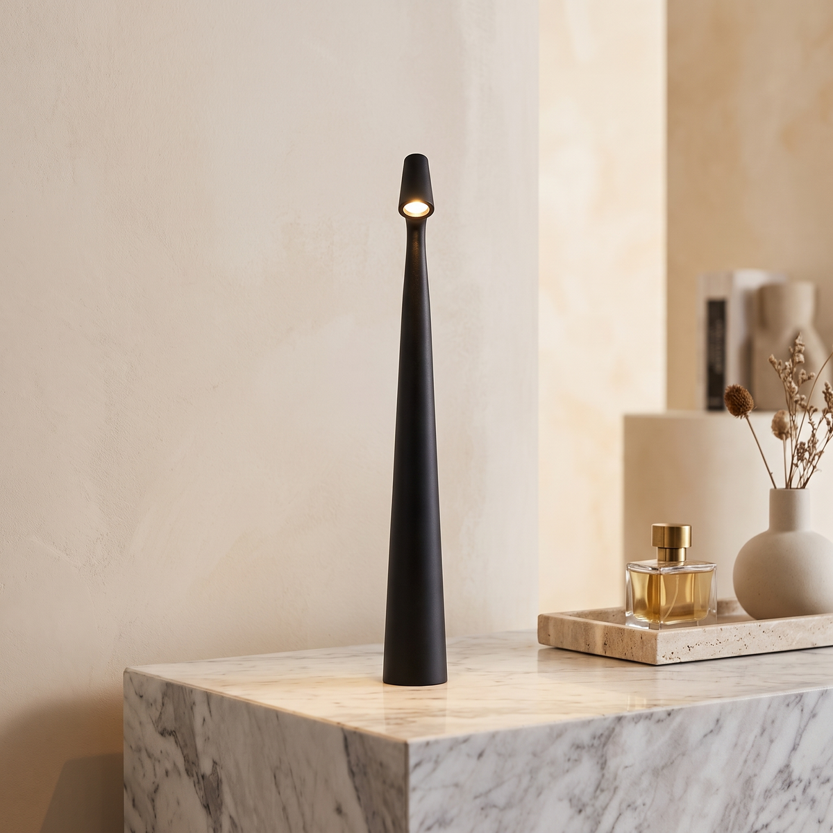 Slim black cordless LED table lamp with a minimalist 33cm tapered design, glowing on a marble console table.
