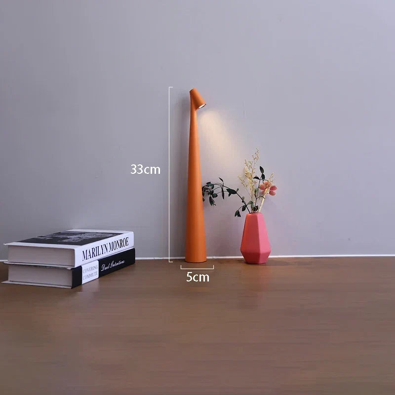 Slim orange cordless LED table lamp, 33cm tall with a 5cm base, featuring a minimalist design on a wooden surface.