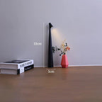 Slim black cordless LED table lamp, 33cm tall with a 5cm base, shown on a desk next to books and a small vase.