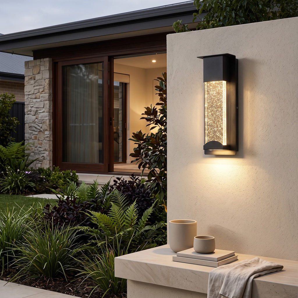 Crystal Effect Outdoor Wall Light – STEADY in a garden wall above lush planting at dusk