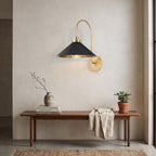 Curved Arm Cone Wall Light – Brass+Black in an entrance hall above a slim walnut bench