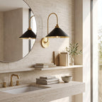 Curved Arm Cone Wall Light – Brass+Black in a spa-like bathroom beside a large round mirror and stone vanity