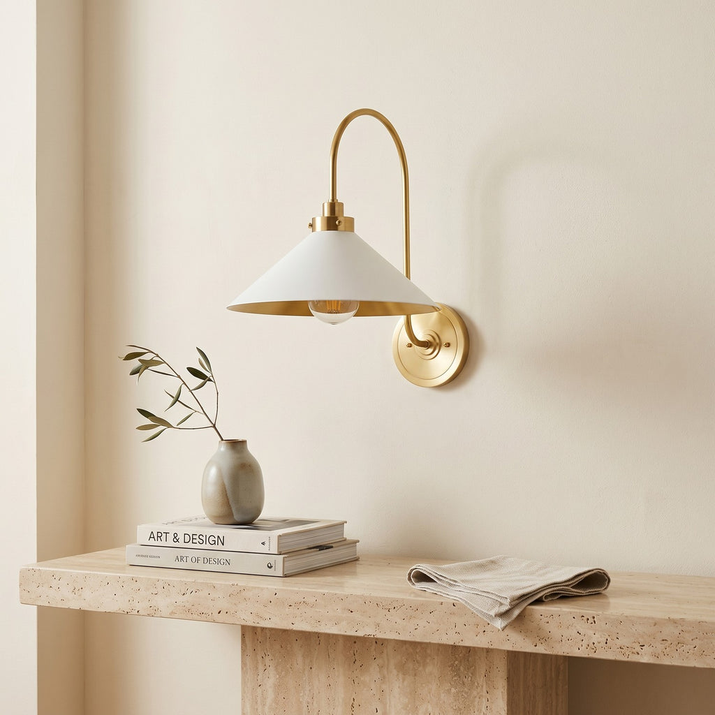 Curved Arm Cone Wall Light – Brass+White in a bright living room above a travertine console