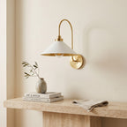 Curved Arm Cone Wall Light – Brass+White in a bright living room above a travertine console