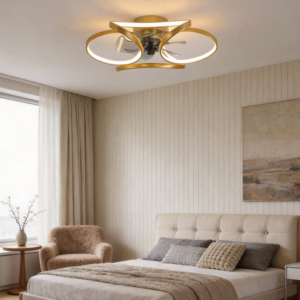Modern gold flush mount ceiling fan with integrated LED light and sculptural petal-shaped design in a bedroom.