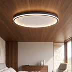 Minimalist black circular LED flush ceiling light with a soft, glare-free silicone diffuser mounted on a wooden ceiling.