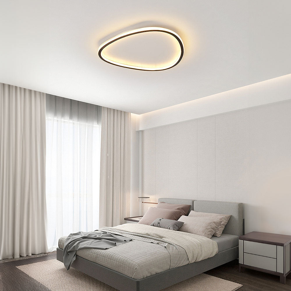 Minimalist black slim LED flush ceiling light with a soft silicone diffuser in a modern bedroom setting.