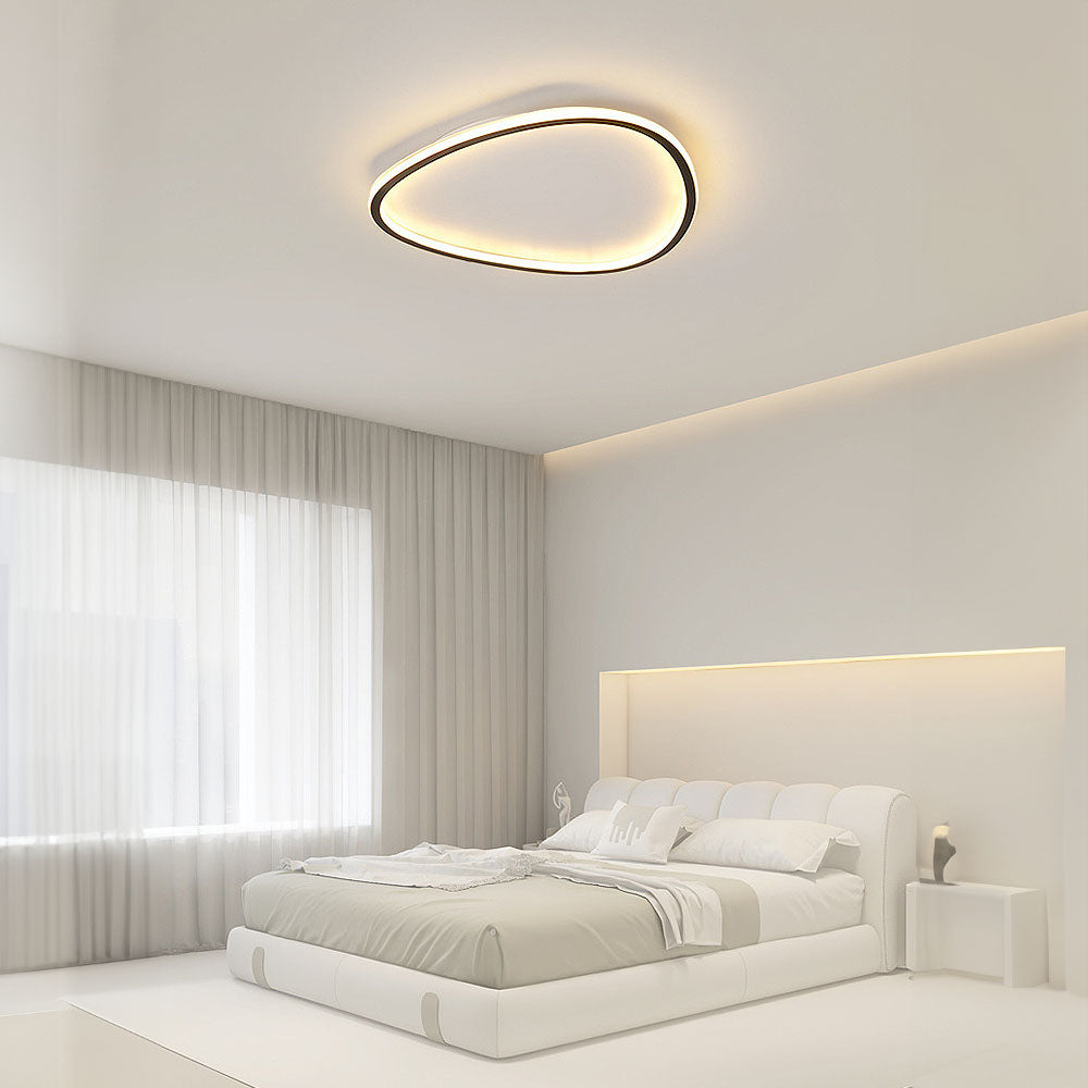 Minimalist black slim LED flush ceiling light with a soft silicone diffuser, mounted in a bright modern bedroom.