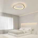 Minimalist black slim LED flush ceiling light with a soft silicone diffuser, mounted in a bright modern bedroom.