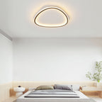 Minimalist black slim LED flush ceiling light with a soft, continuous silicone diffuser in a modern bedroom.