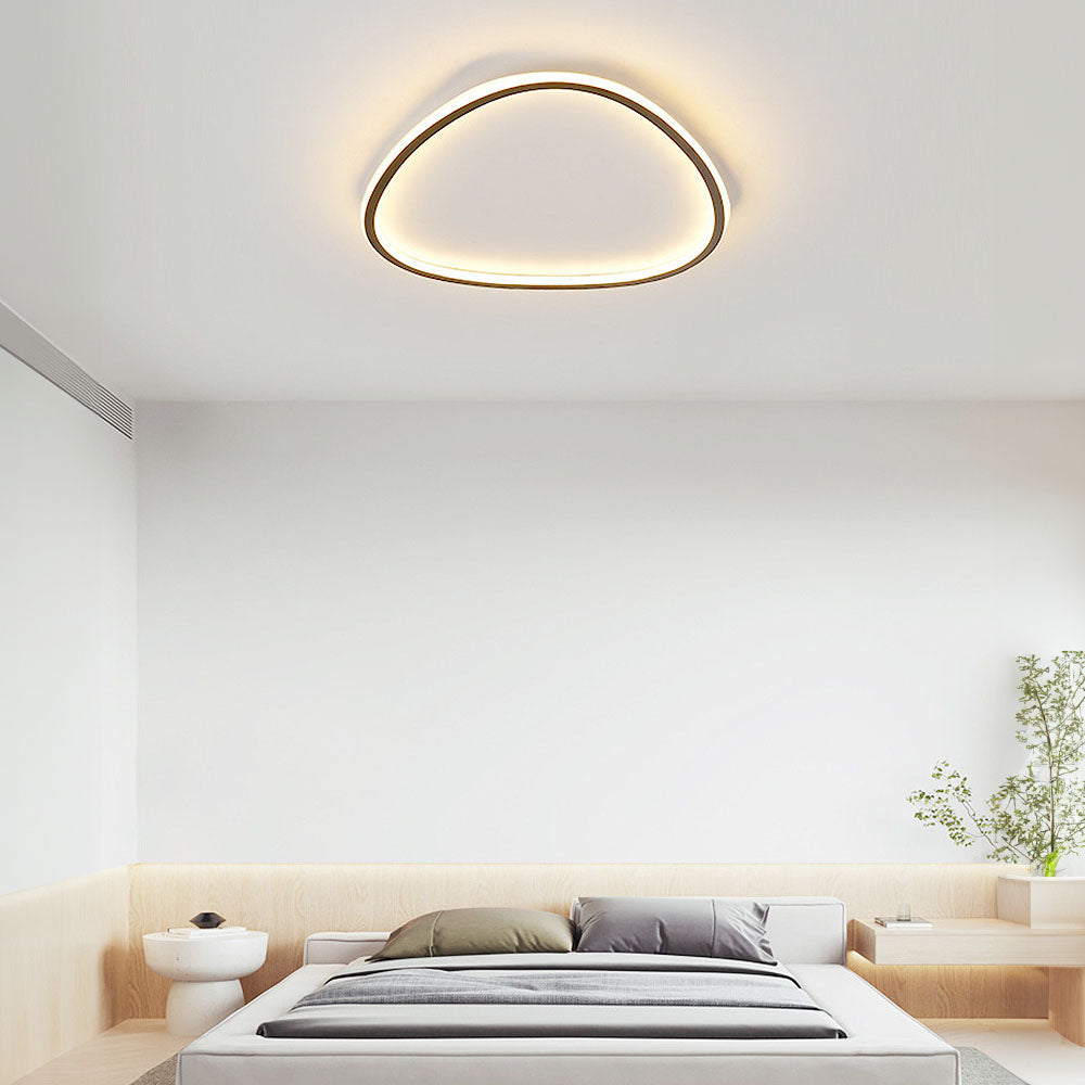 Minimalist black slim LED flush ceiling light with a soft, continuous silicone diffuser in a modern bedroom.