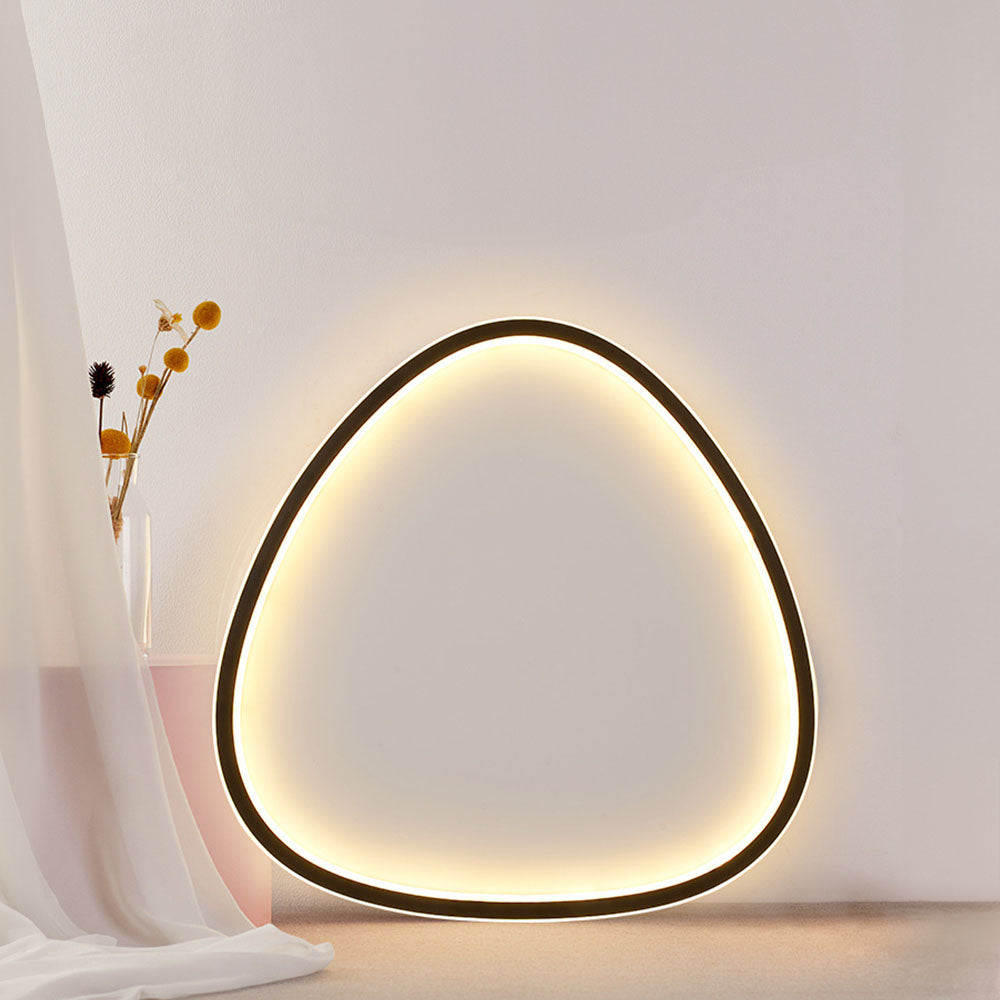 Minimalist triangular LED flush ceiling light with a black aluminum frame and soft, glare-free silicone diffuser.