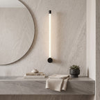 LED Tube Wall Light – Black-end in a spa-like bathroom beside a large round mirror and stone vanity