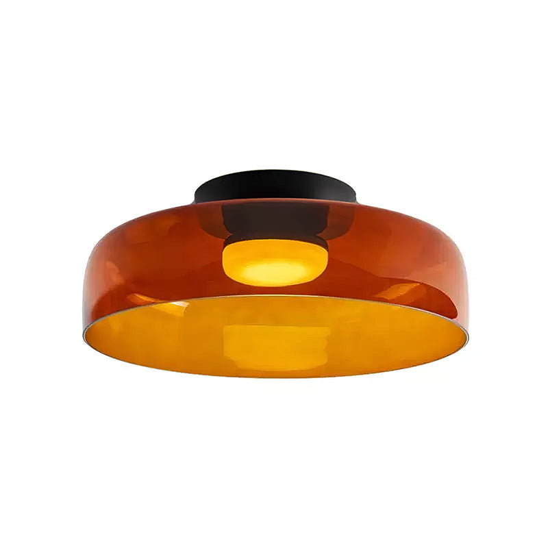 Retro orange layered glass ceiling light with a black mount, casting a warm, glowing light in a sculptural, tiered design.