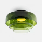 Retro green layered glass ceiling light with stacked tiers and a warm glowing center bulb.