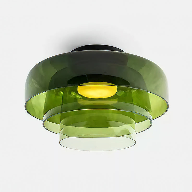 Retro green layered glass ceiling light with stacked tiers and a warm glowing center bulb.