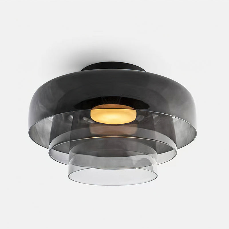 Retro layered ceiling light in smoky grey glass with stacked tiers and a warm glowing center.