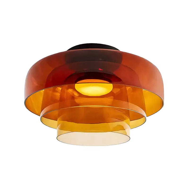 Retro layered ceiling light featuring stacked orange glass tiers that create a warm, glowing gradient effect.