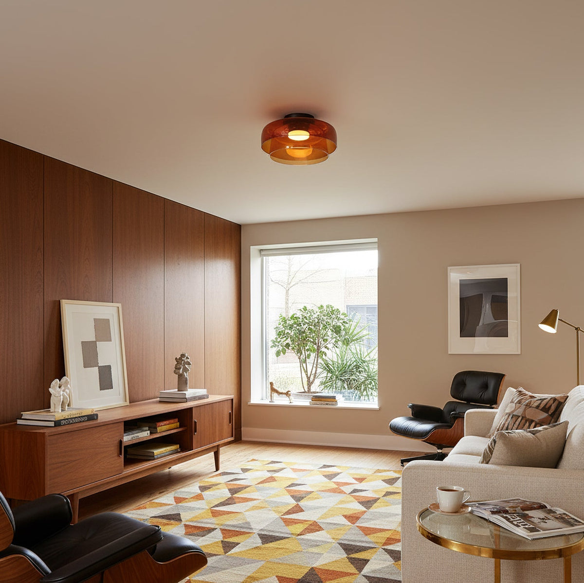 Retro layered orange glass ceiling light fixture in a mid-century modern living room with wood paneling.