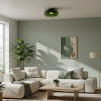 Retro layered green glass ceiling light fixture mounted in a modern living room with a cream sectional sofa.