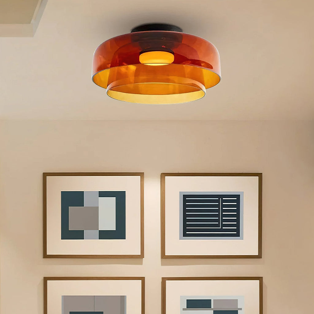 Retro layered orange glass ceiling light with a stacked design, casting a warm glow in a modern interior.