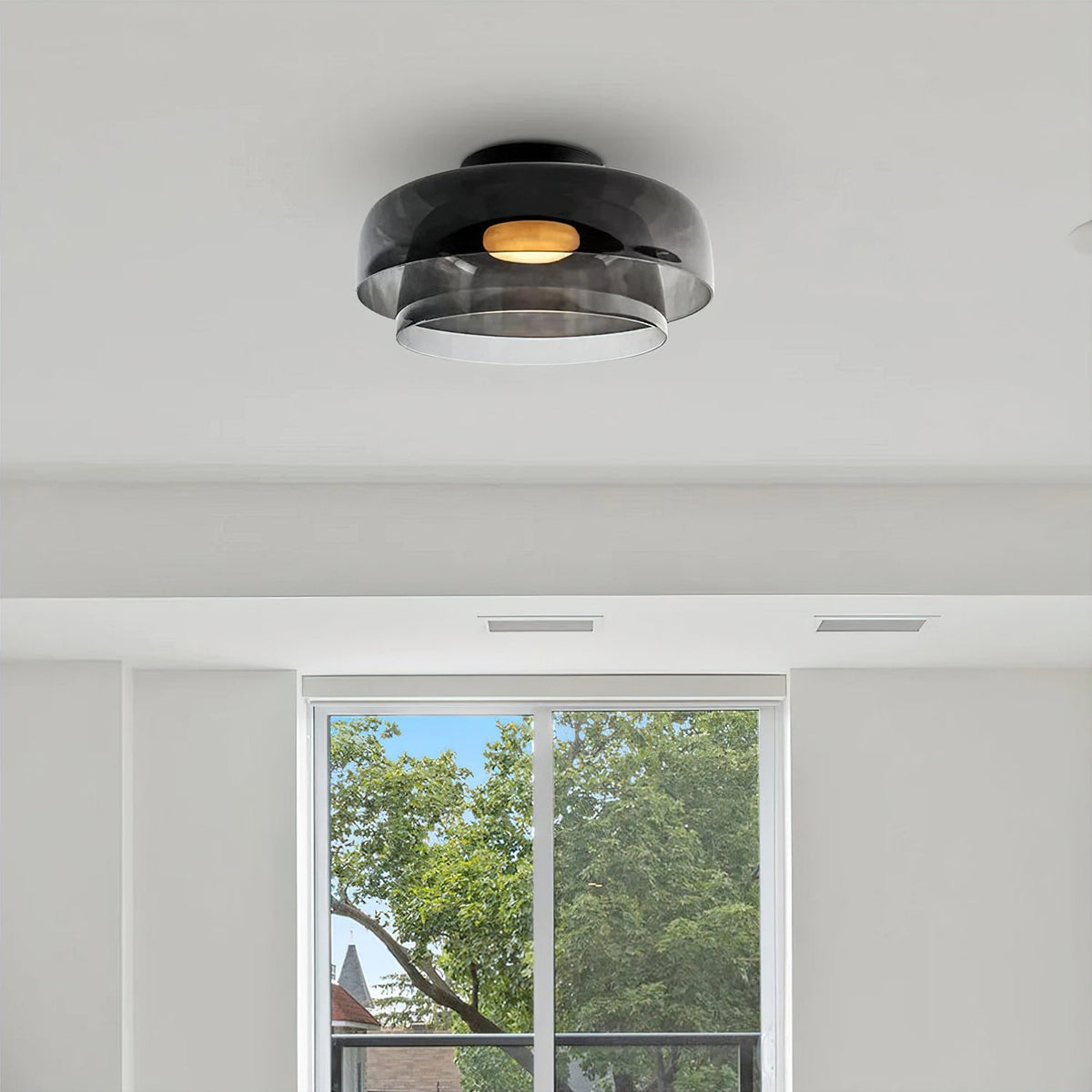 Retro layered ceiling light with smoky grey glass tiers and a warm glowing center, mounted on a white ceiling.