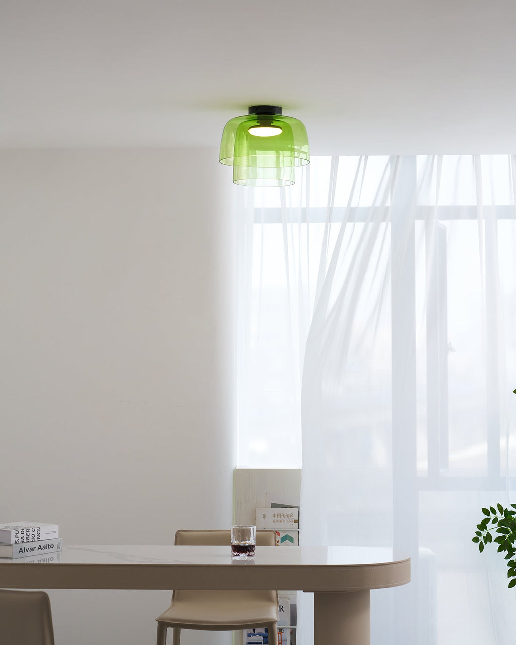Retro layered green glass ceiling light with stacked tiers, illuminating a modern dining room interior.