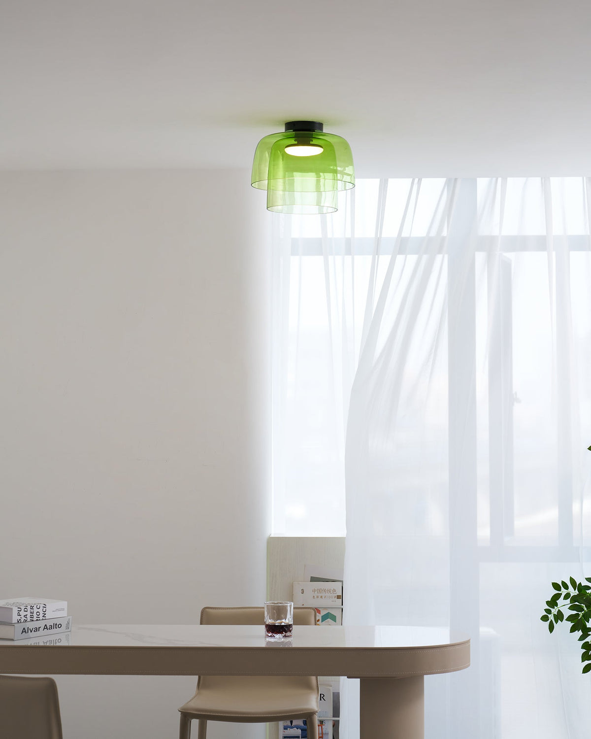 Retro layered green glass ceiling light with stacked tiers, illuminating a modern dining room interior.