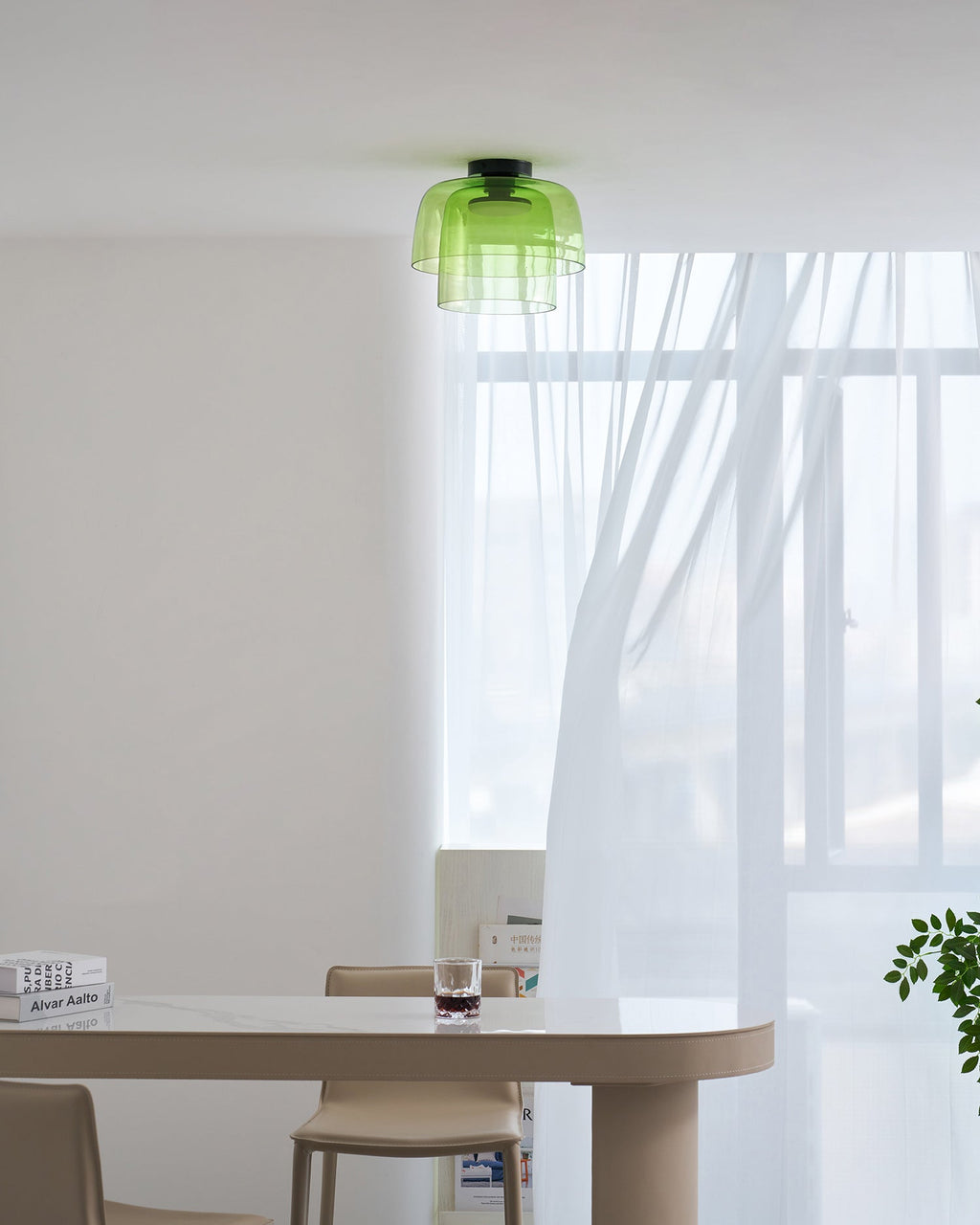Retro layered green glass ceiling light with a stacked design, mounted in a bright, modern dining room interior.