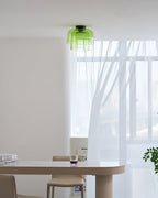 Retro layered green glass ceiling light with a stacked design, mounted in a bright, modern dining room interior.