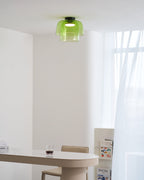Retro layered green glass ceiling light with a stacked design, mounted in a bright, modern interior space.