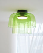 Retro layered green glass ceiling light with a stacked design and warm glowing center bulb.