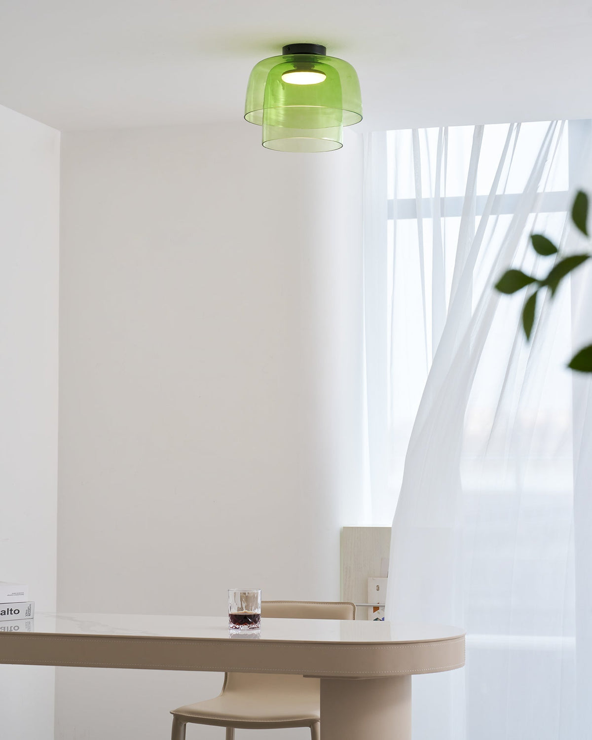 Retro layered green glass ceiling light with a stacked design, mounted above a modern dining table.