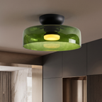 Retro green layered glass ceiling light with a black mount and warm glowing center bulb in a modern interior.