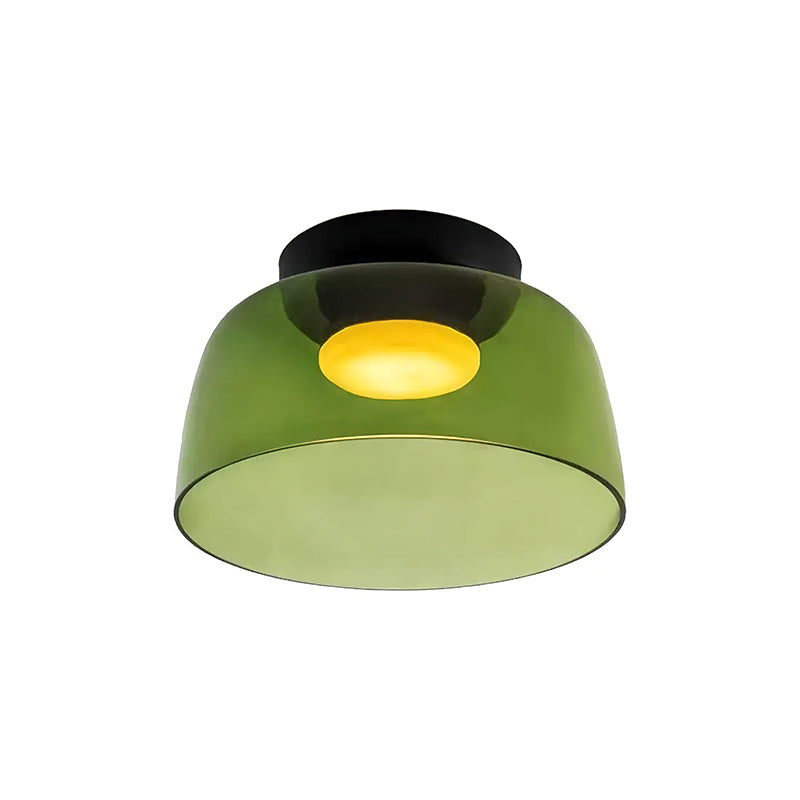 Retro green glass ceiling light with a layered design and warm glowing center, mounted on a black base.