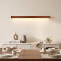 Linear Wood LED Wall Light – Brown in an elegant dining room above a marble sideboard