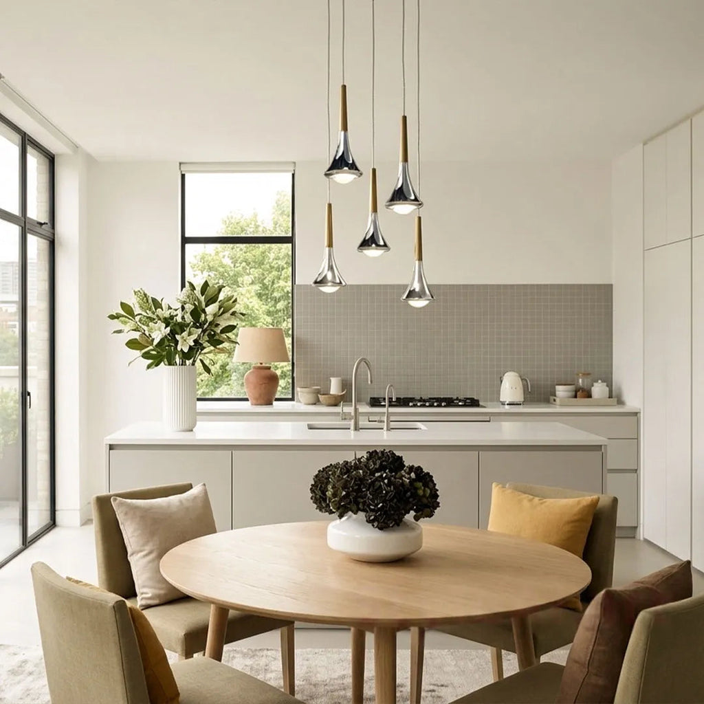 Five chrome and wood teardrop LED pendant lights hanging over a modern kitchen island and dining area.