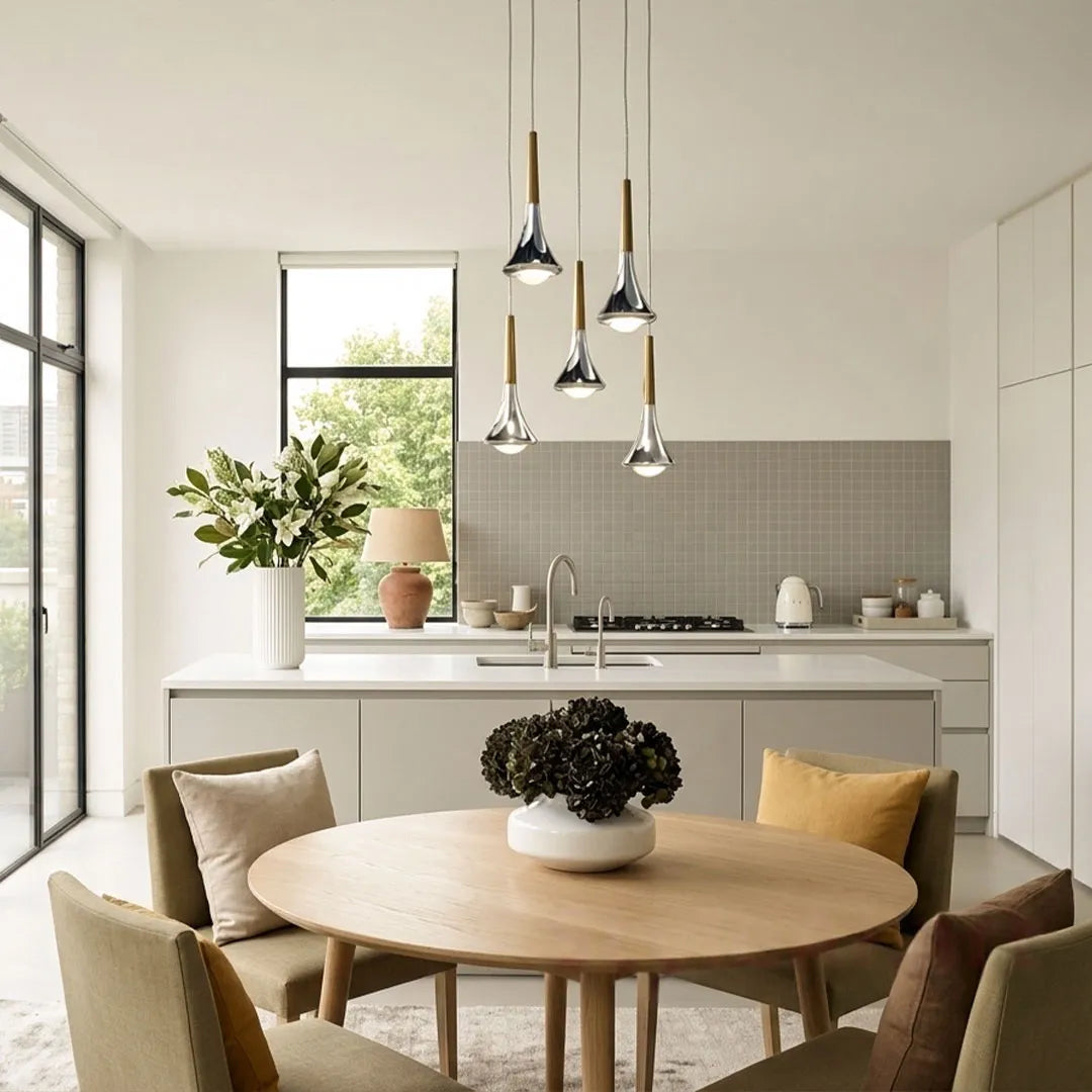Five chrome and wood teardrop LED pendant lights hanging over a modern kitchen island and dining area.