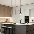 Three modern chrome teardrop pendant lights hanging over a kitchen island with a sleek, minimalist design.
