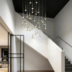 Modern gold teardrop LED pendant lights hanging in a cluster above a contemporary staircase.