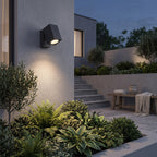 Outdoor Spotlight Wall Light – in a garden wall above lush planting at dusk
