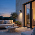 Outdoor Spotlight Wall Light – in a stone terrace beside large glass doors at dusk