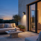 Outdoor Spotlight Wall Light – in a stone terrace beside large glass doors at dusk