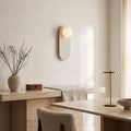Oval Marble Wall Light – Beige in an elegant dining room above a marble sideboard