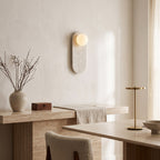 Oval Marble Wall Light – Beige in an elegant dining room above a marble sideboard